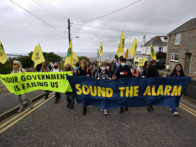 Activists from the climate change protest group Extinction Rebellion take part in a protest march in St. Ives, Cornwall, on June 11, 2021, on the first day of the three-day G7 summit being held from June 11-13.
